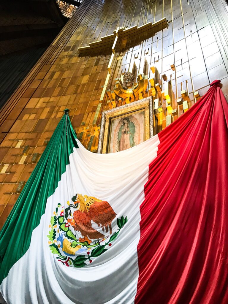 Bandeira mexicana sobre La Virgen de Guadalupe dentro da Basílica de Guadalupe na Cidade do México.